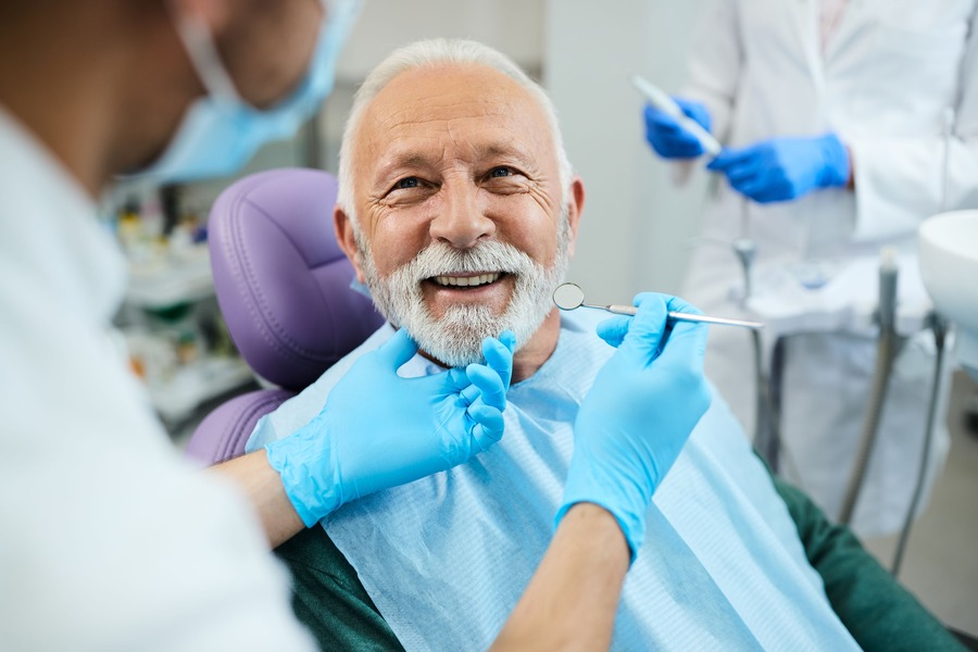 Older patient smiling during a dental exam