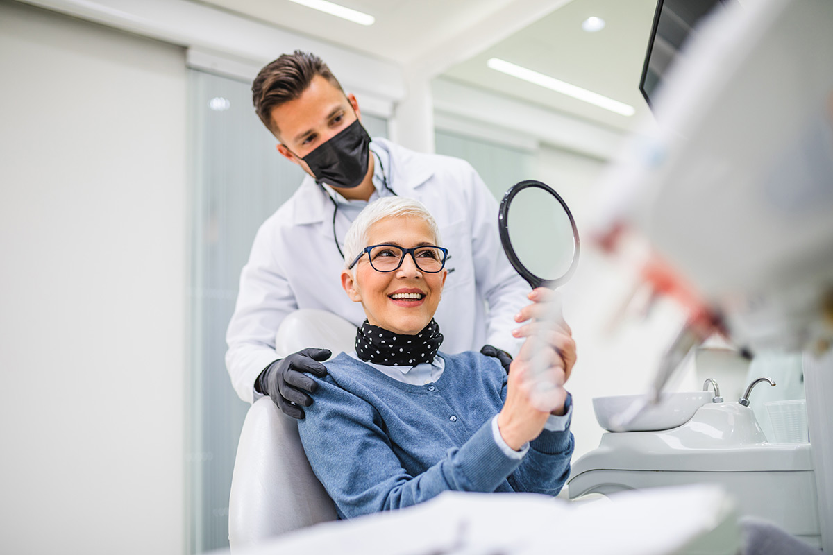 Dentist reviewing a patient's smile after dental treatment