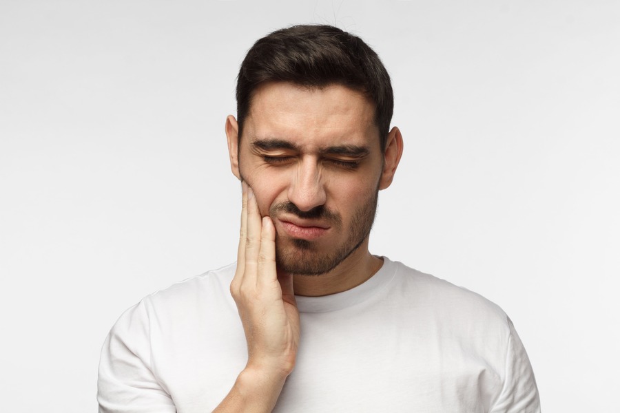 Patient experiencing tooth pain before emergency dental care